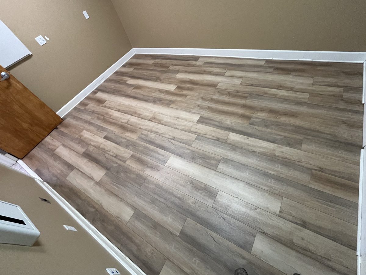 New flooring meeting freshly installed baseboard