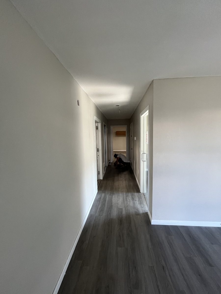 Hallway with new flooring and freshly painted white walls