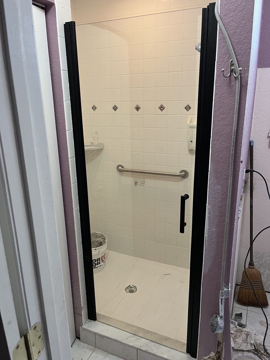 Remodeled walk-in tile shower with glass door